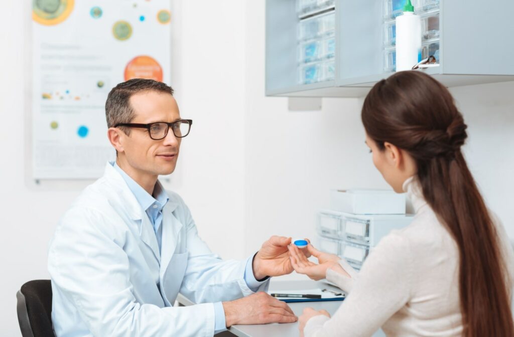 An optometrist giving his patient a pair of contact lenses.