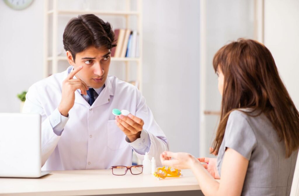 An optometrist explaining contact lens wear and care to his patient during a contact lens fitting.