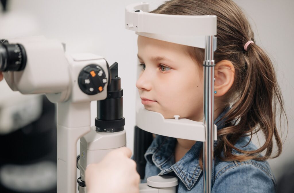 A child getting a slit lamp exam as part of their OHIP covered annual eye exam.