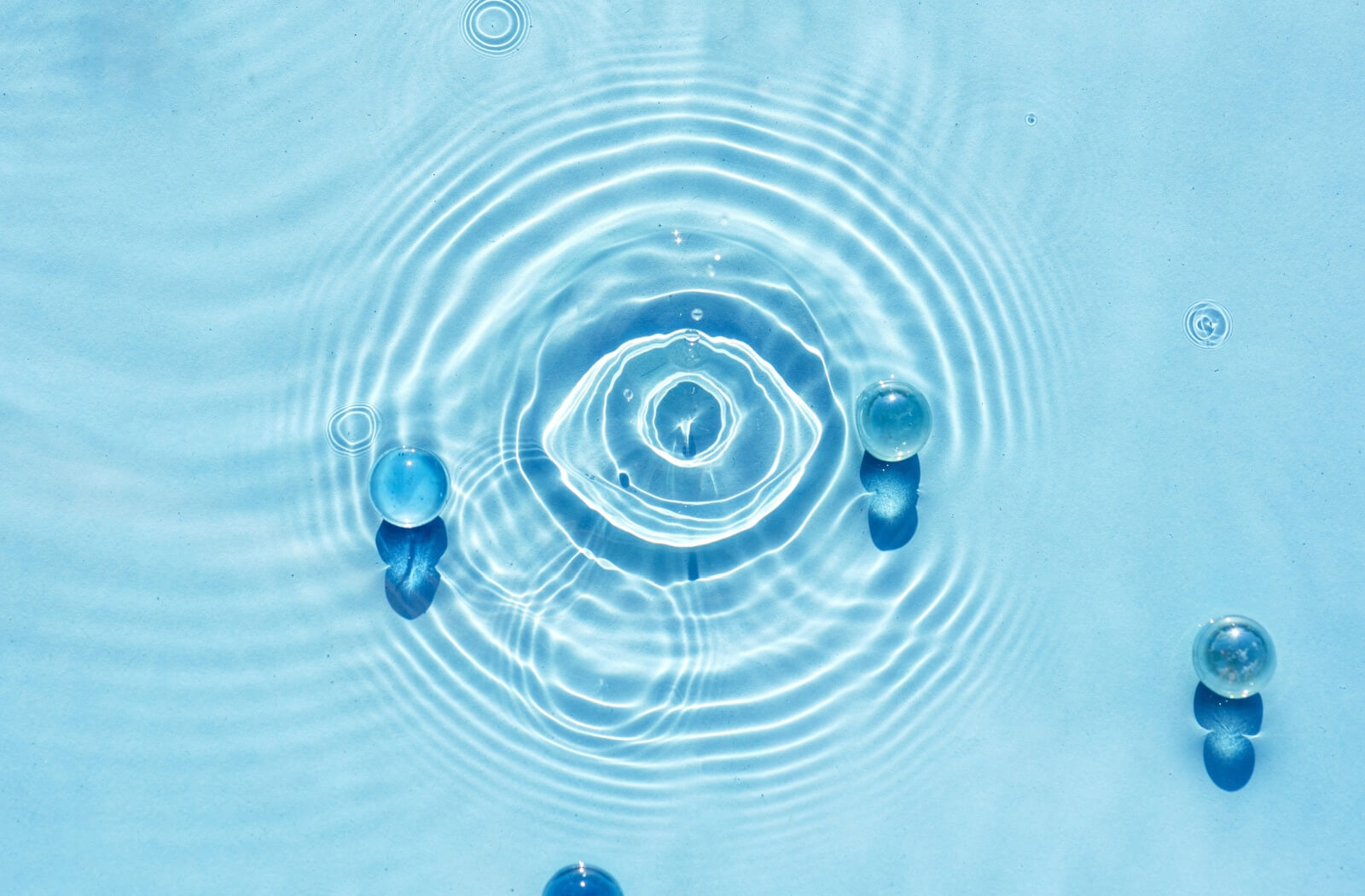 An image of an eye created in the ripples of a pool of water.